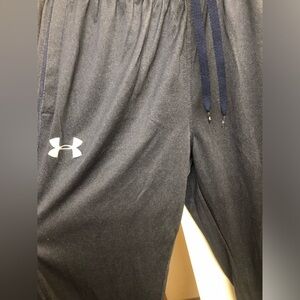 Under armor dark blue track pants with zipper bottom.